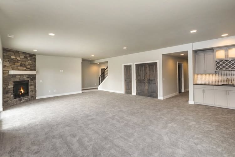 Waukesha basement remodel including entertainment space with built-in shelving and carpeting