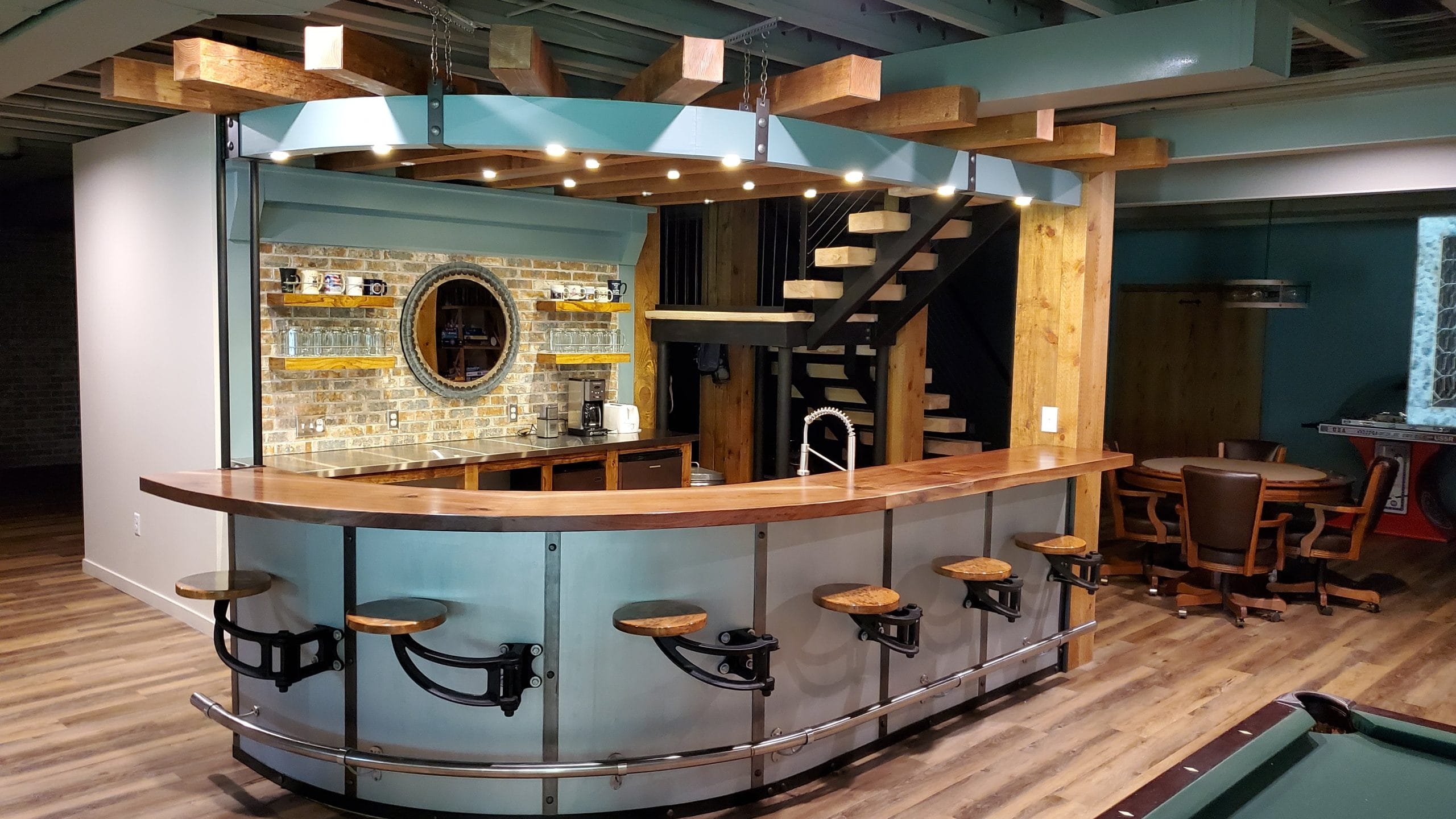 Custom basement bar in Mequon with wood cabinetry, countertop, and overhead pendant lighting