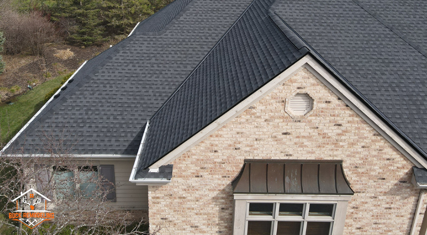 Roof inspector walking along shingles on a Delafield home, examining flashing details