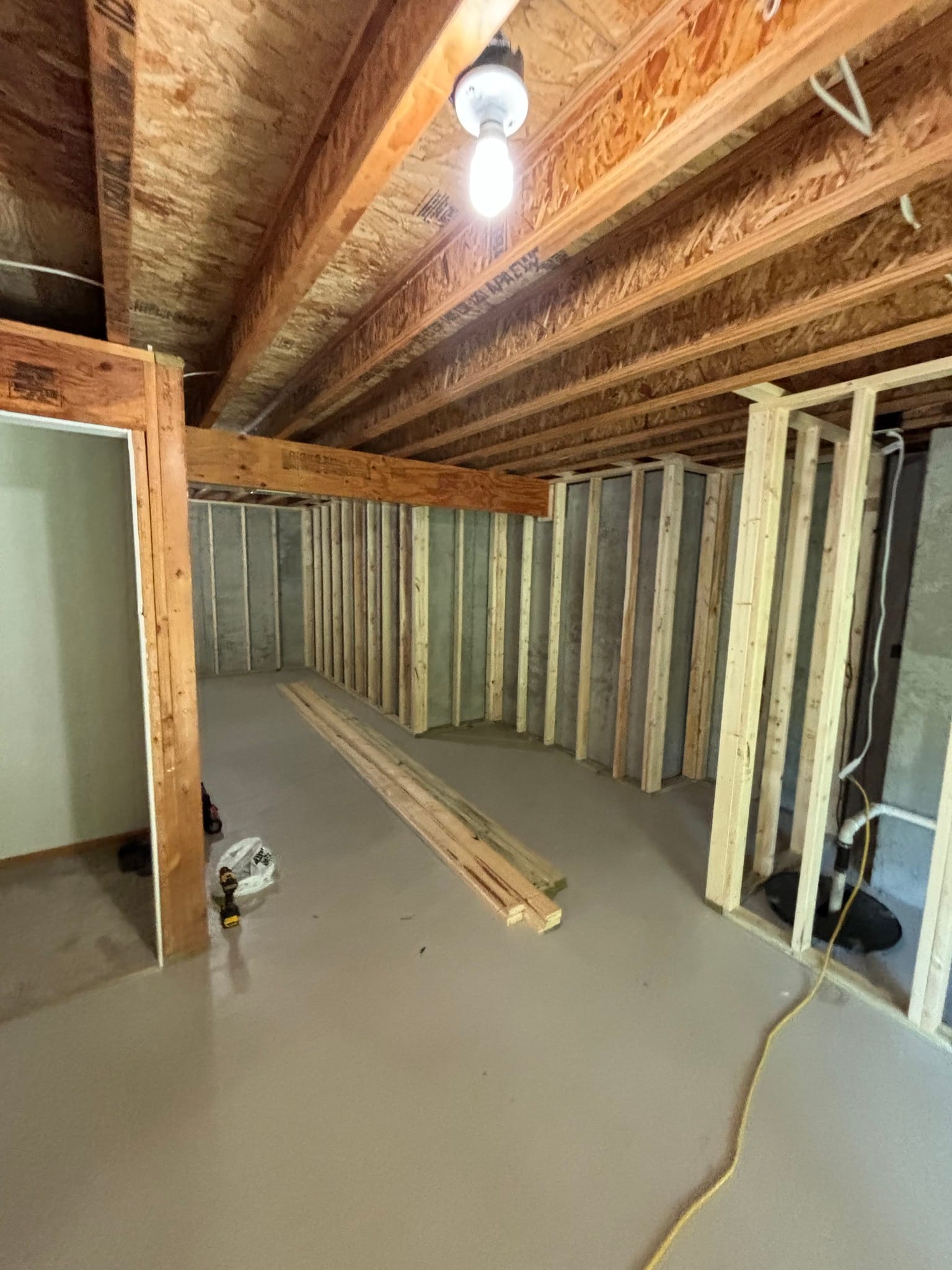 Ceiling joists and wall framing forming new room layout in unfinished interior