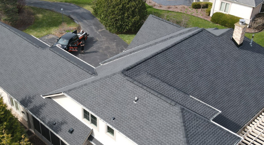 Low-slope commercial roof with fresh membrane coating and rooftop HVAC equipment visible