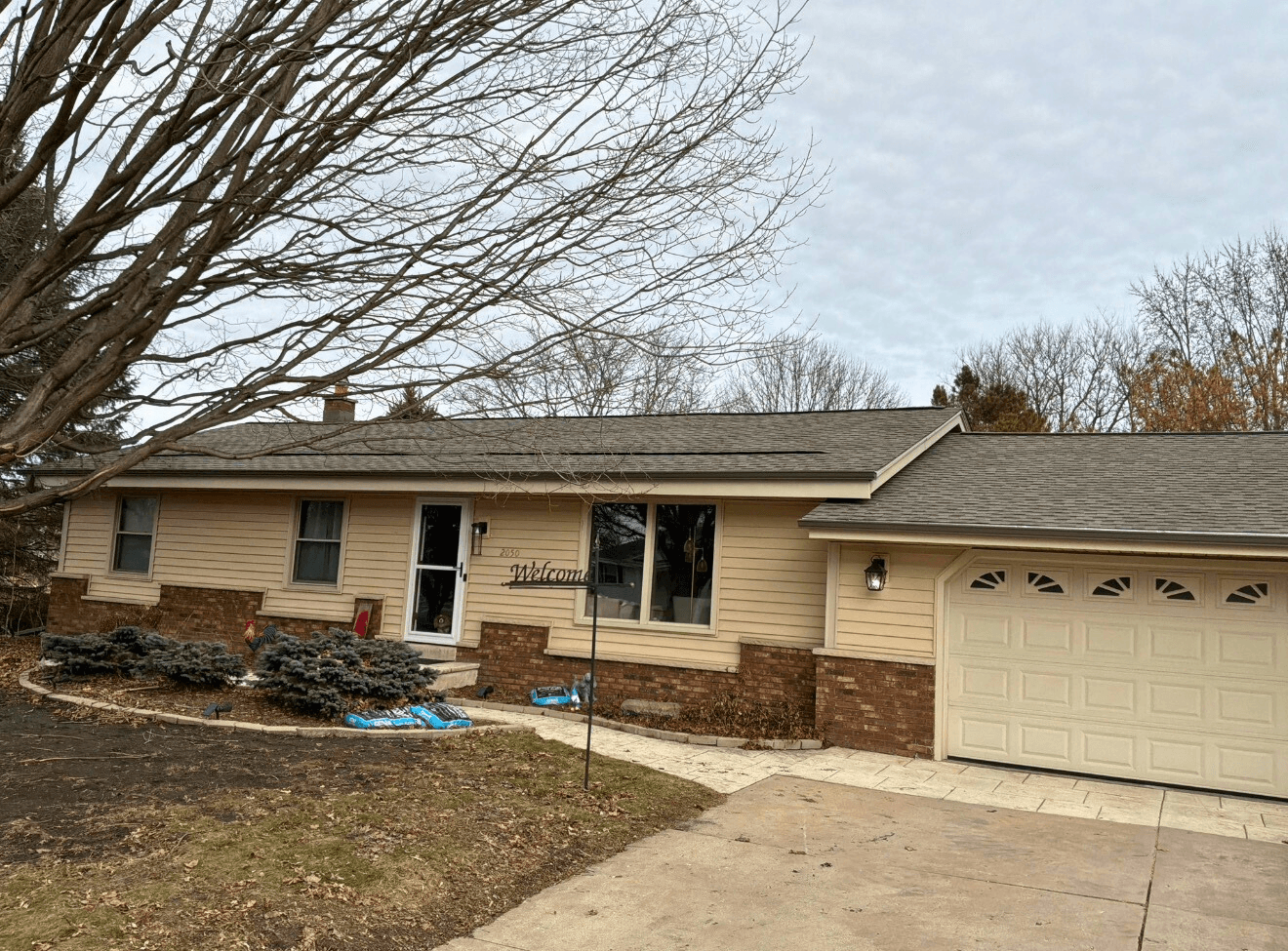 Contractors removing old shingles during roof replacement on Waukesha house