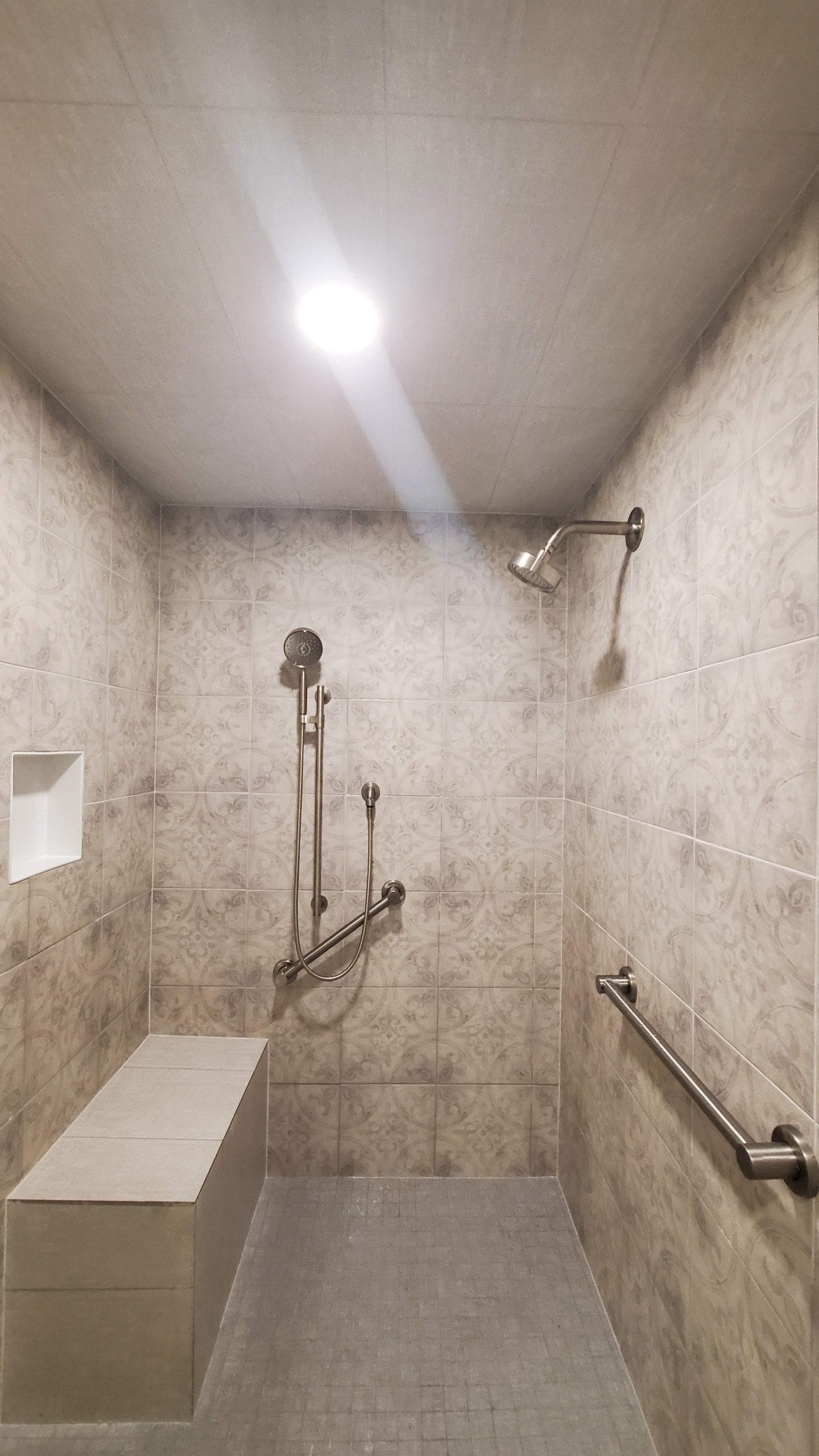 Modern shower featuring subway tile walls, built-in niche, and chrome fixtures