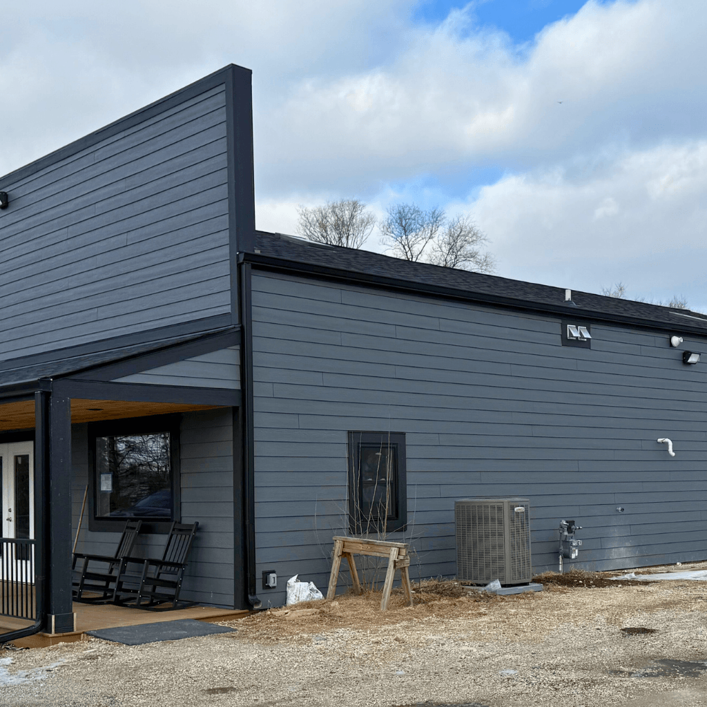 Close view of new vinyl siding meeting asphalt shingle roof on Hartland house